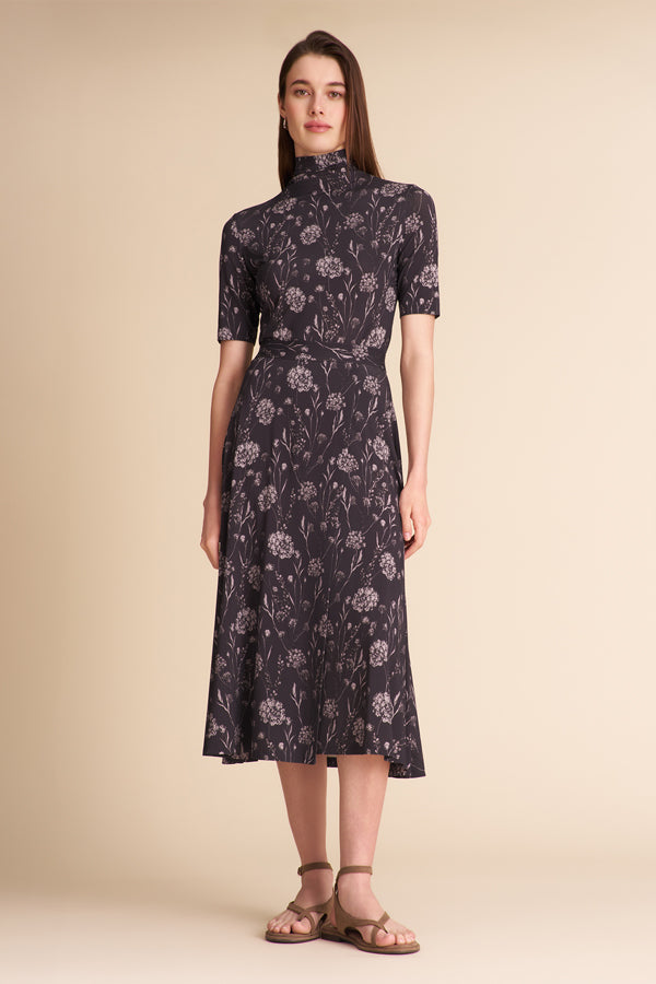 Woman wearing a dark floral matching top and skirt on a beige background | Exclude