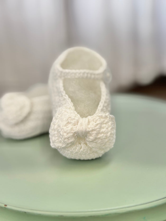 Crochet baby booties with crochet bow.