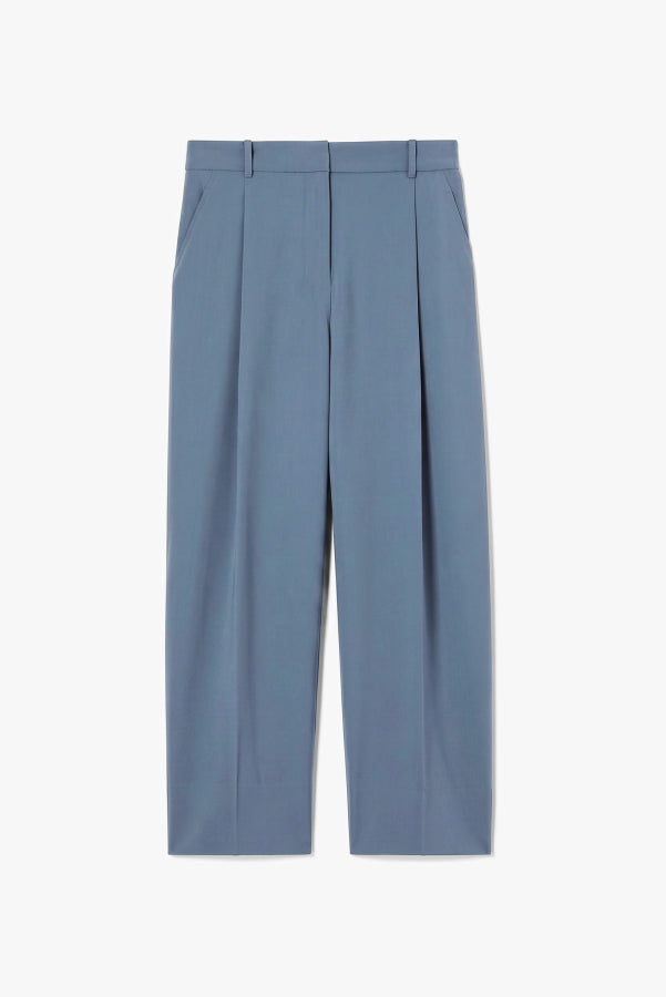 A pair of slate blue cropped trousers with front pleats, shown flat against a light gray background. | Exclude | Still