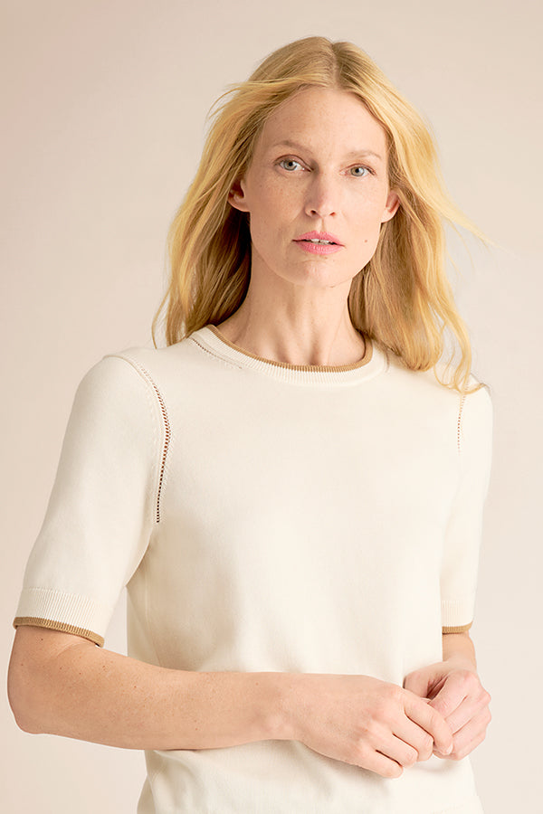 Woman wearing a white blouse against a beige background | Exclude | Grid