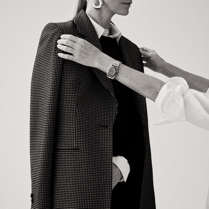 image of a woman adjusting a blazer on her client | Lead