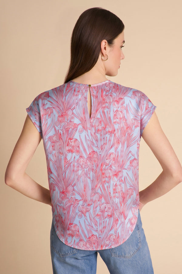 Woman wearing a patterned top and jeans on a beige background | Exclude