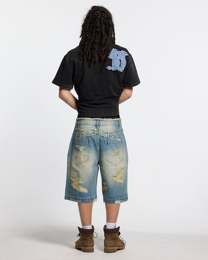 DISTRESSED DOLLAR POLO BLACK - black polo with denim applique, back view on male model - Cold Culture