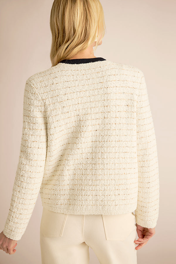 Person wearing a textured cream jacket against a plain background | Exclude