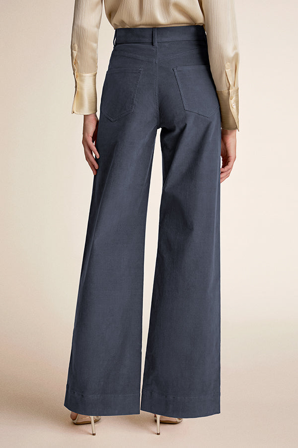 Dark blue wide-leg pants worn by a person on a beige background | Exclude