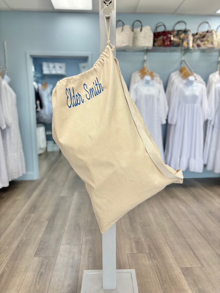 Canvas laundry bag with embroidered name.