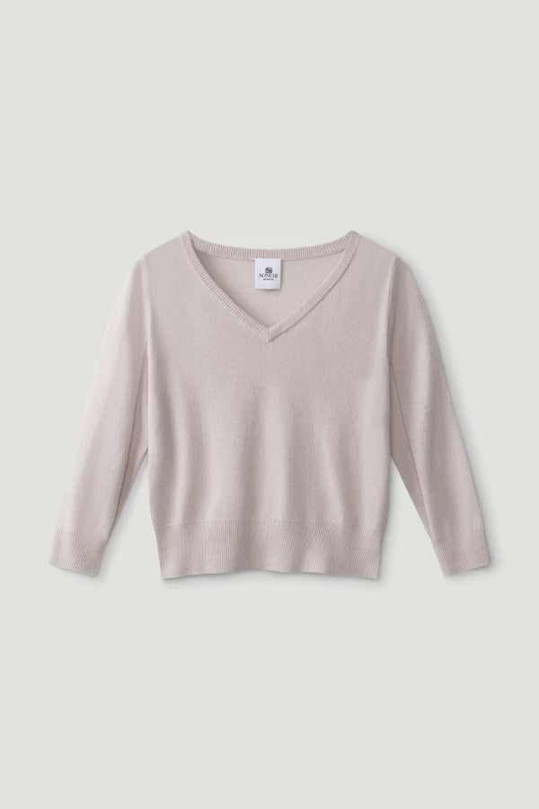Light pink sweater with a V-neck on a light gray background | Grid | Exclude