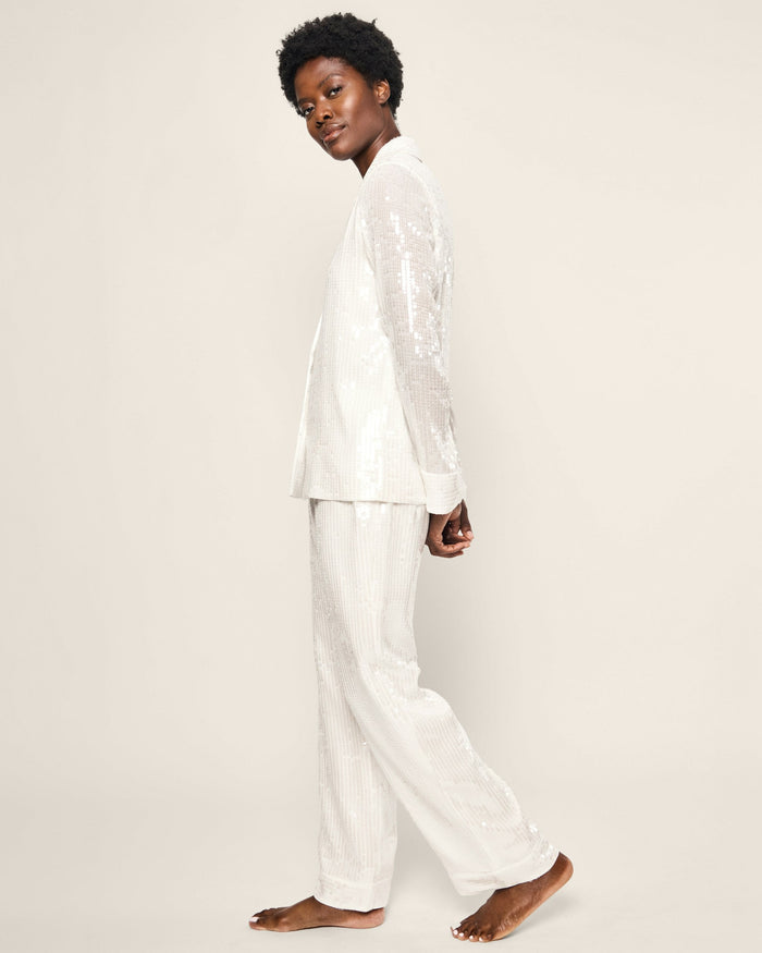 Person wearing a white pajama set on a plain background