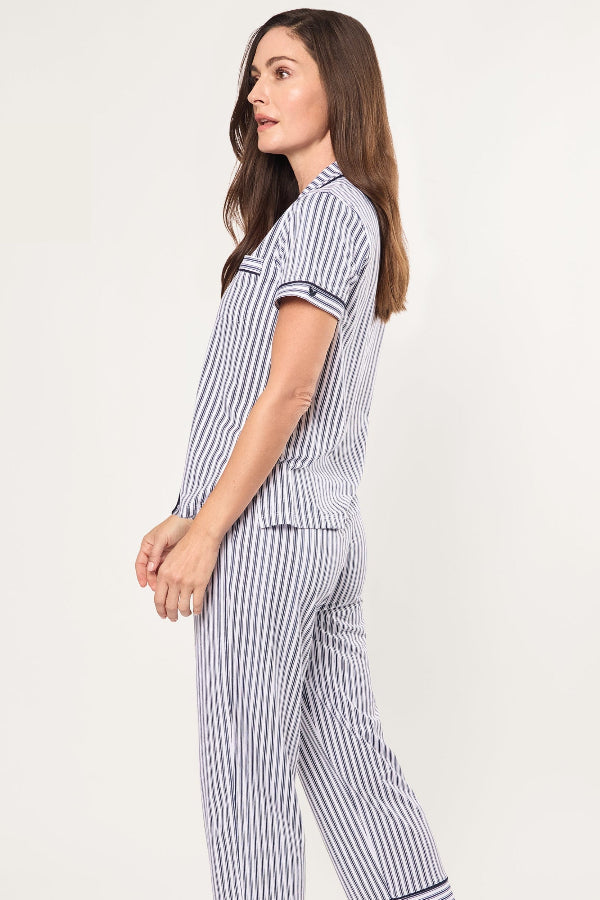 Woman wearing a blue and white striped pajama set on a light gray background | Grid Hover | Exclude