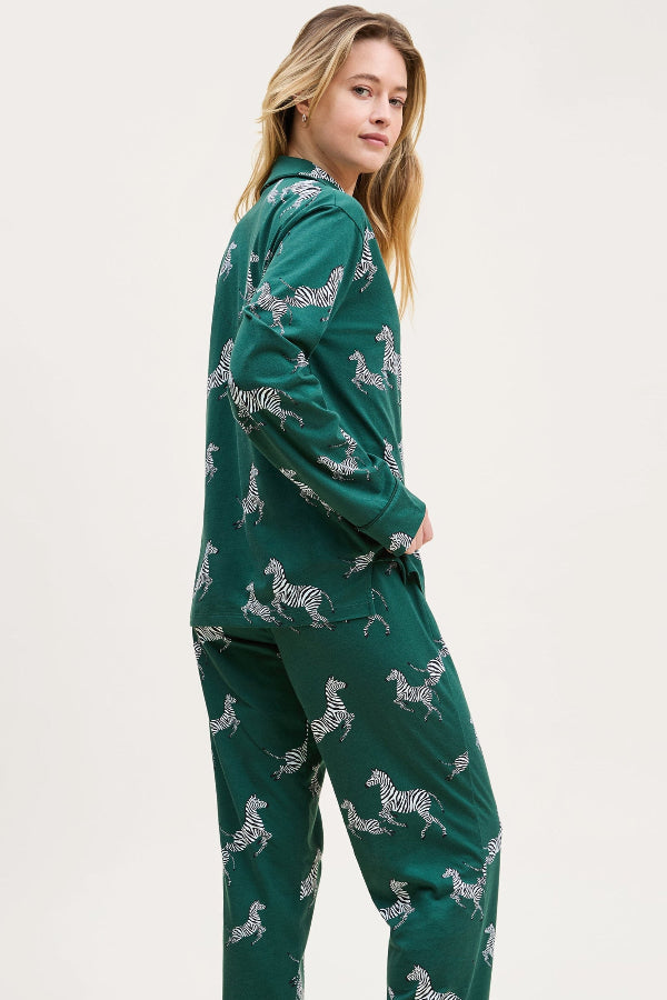 Woman wearing a green pajama set with zebra pattern on a white background | Grid Hover | Exclude