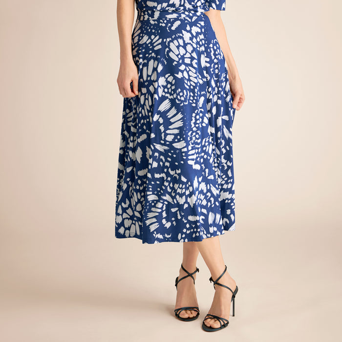 Woman wearing a blue and white patterned dress on a beige background | Lead
