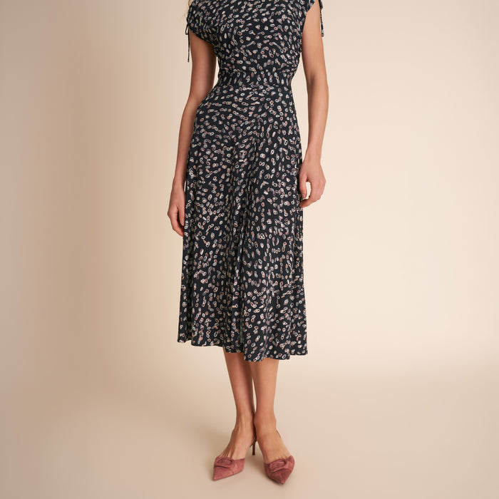 Woman wearing a black and white patterned dress on a beige background | Lead