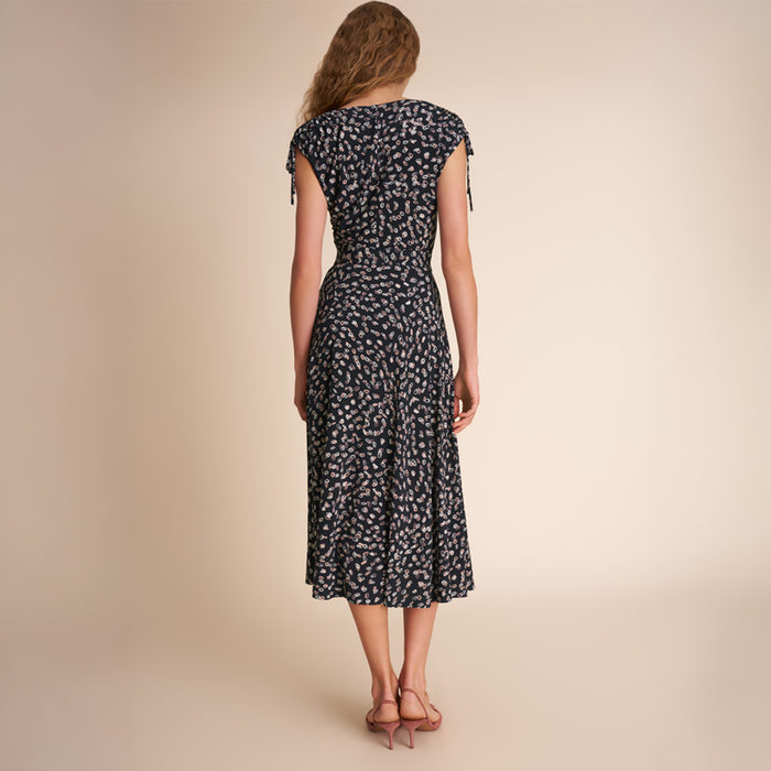 Woman wearing a black floral dress on a beige background