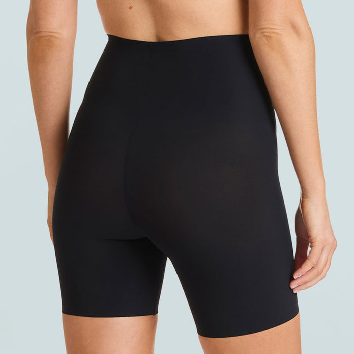 Person wearing black high-waisted shorts on a light gray background