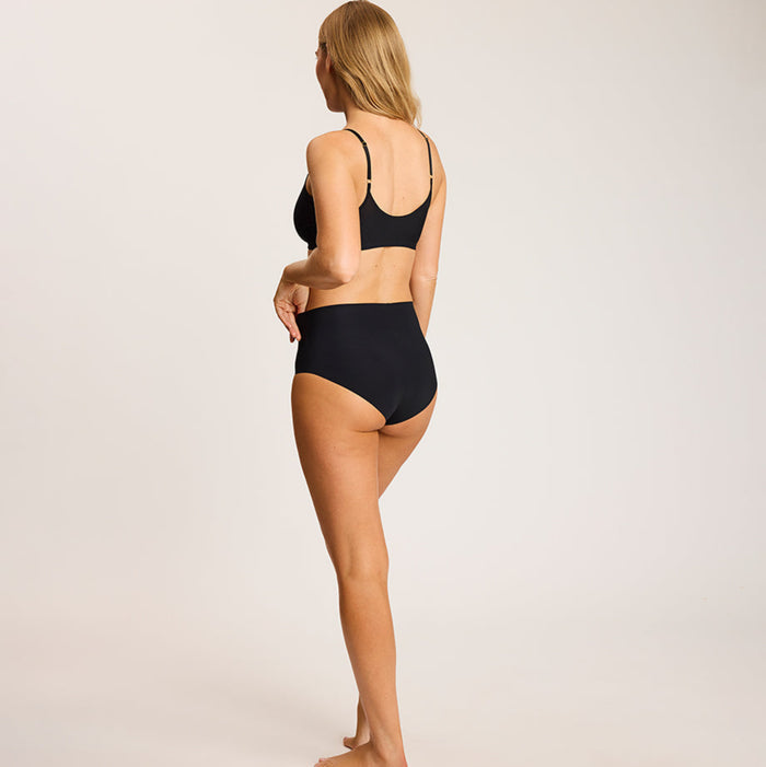 Woman wearing a black set on a beige background