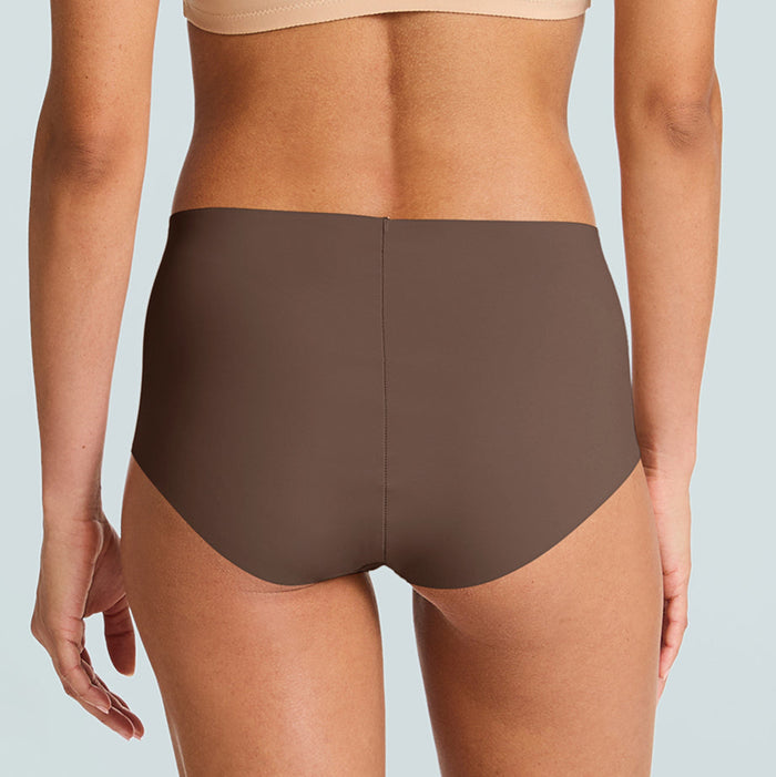 Person wearing a beige sports bra and brown high-waisted underwear on a light blue background