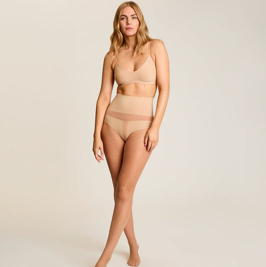 Woman wearing beige lingerie on a plain background | Lead