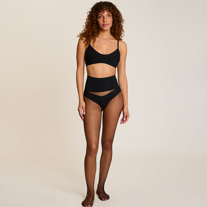Woman wearing a black set on a beige background