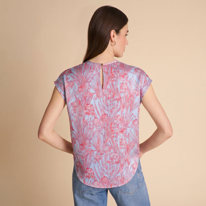Woman wearing a patterned top and jeans on a beige background