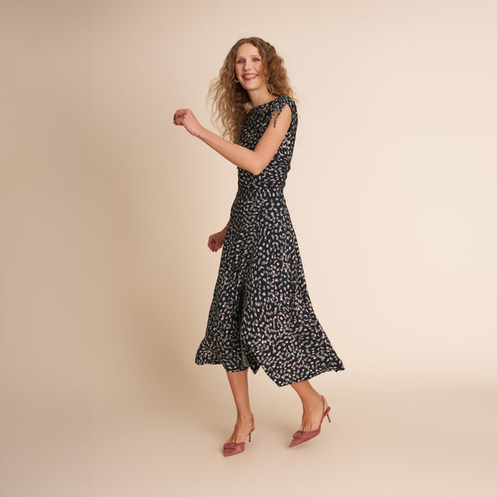 Woman wearing a black floral dress on a beige background