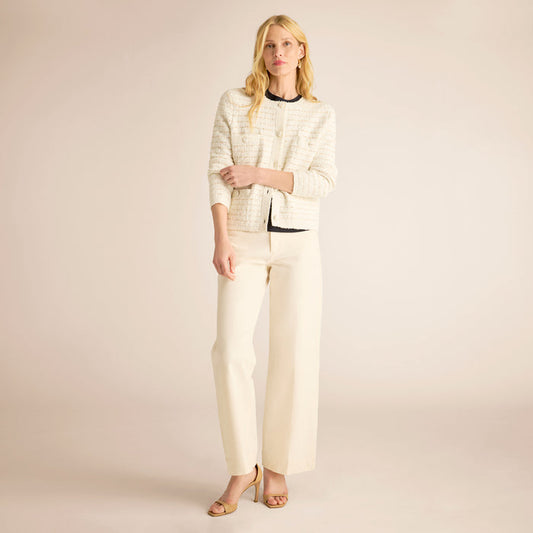 Woman wearing a cream-colored outfit against a plain background | Lead
