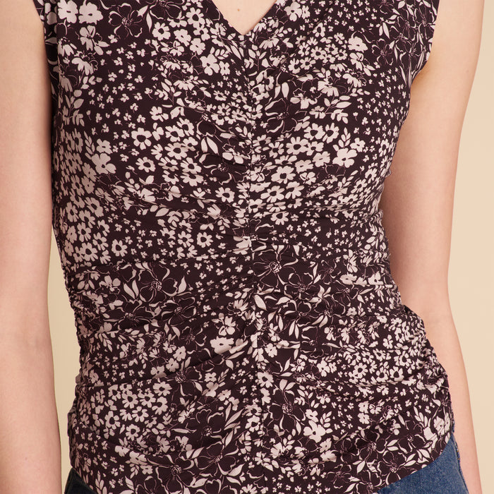Floral patterned top worn by a person on a beige background