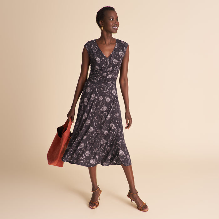 Woman wearing a floral top and matching skirt against a beige background