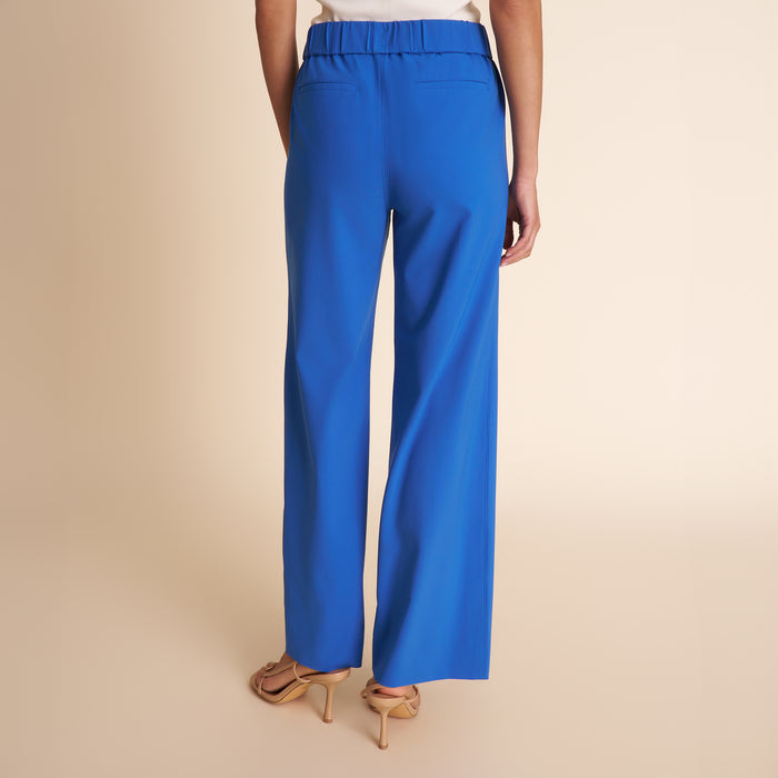 Blue pants worn by a person on a beige background