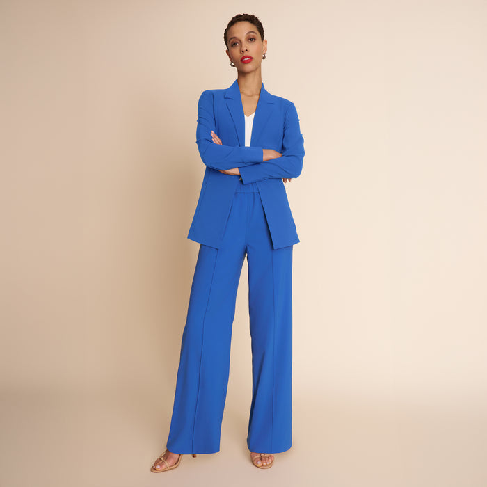Woman wearing a blue suit against a beige background