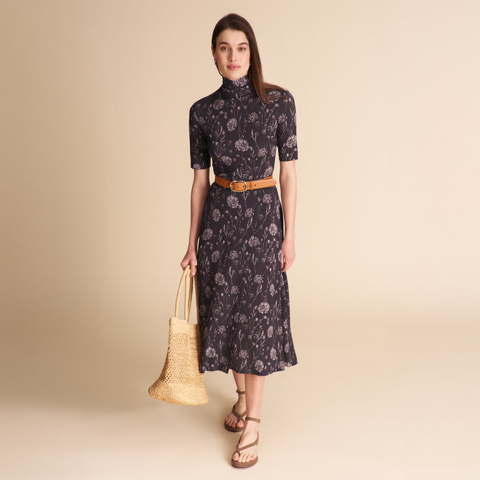 Woman wearing a patterned top and matching skirt on a beige background