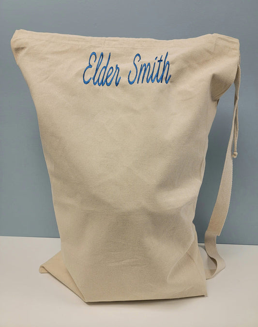 Canvas laundry bag with embroidered name.