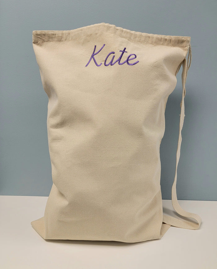 Canvas laundry bag with embroidered name.