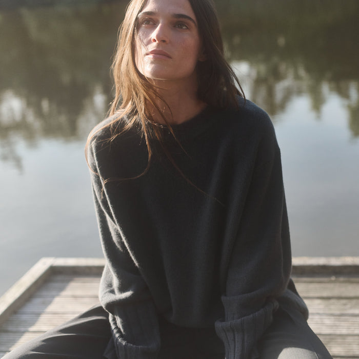 Woman sitting on a wooden dock by a body of water