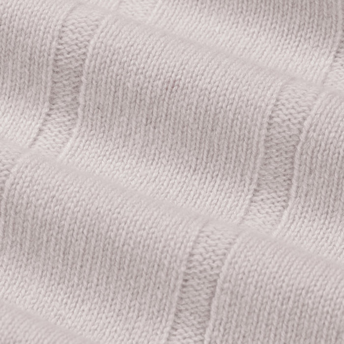 Close-up of a textured light gray fabric with a subtle pattern.