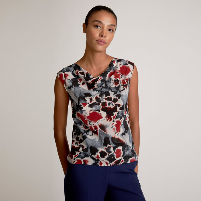 Woman wearing a sleeveless top with a floral pattern on a plain background | Exclude