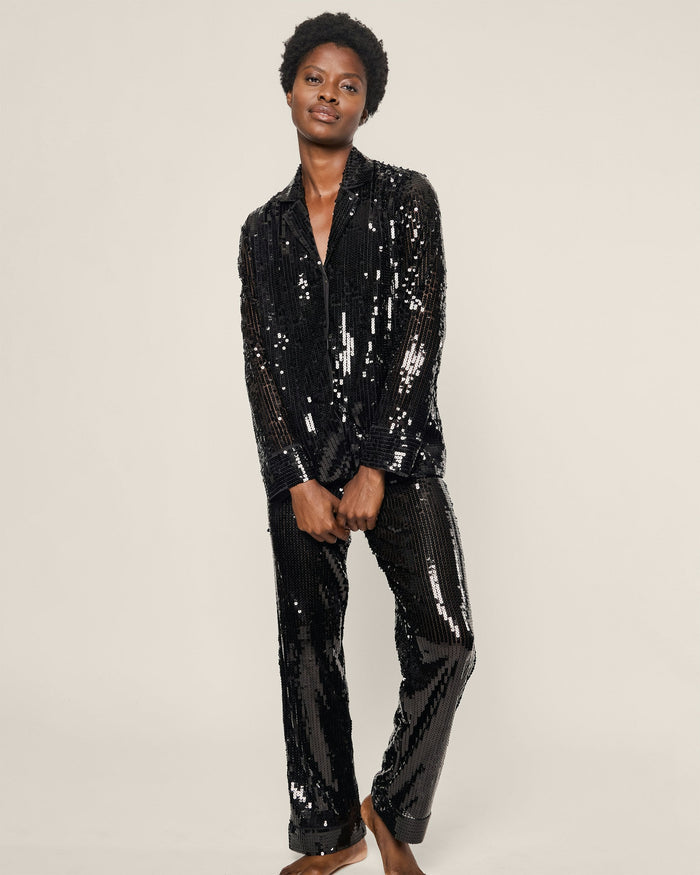 Person wearing a black sequin suit on a plain background