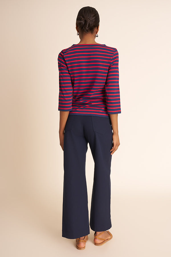 Woman wearing a striped shirt and navy pants on a beige background | Grid Hover | Exclude