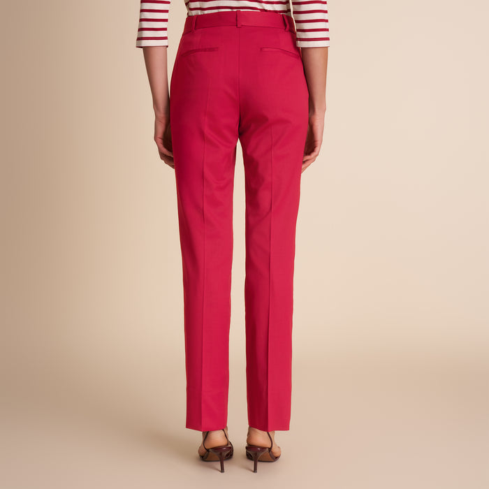Red pants worn by a person on a beige background