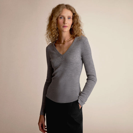 Woman wearing a gray sweater against a beige background | Lead