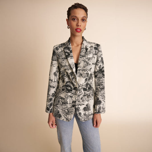 Woman wearing a patterned blazer against a beige background | Lead